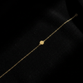 Bracelet minimaliste doré vue de dessus sur velours noir